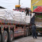 Labourers off-loading sacks of sugar bags from delivery truck at Vegetable Market