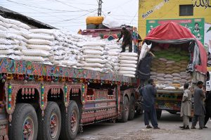 Labourers off-loading sacks of sugar bags from delivery truck at Vegetable Market