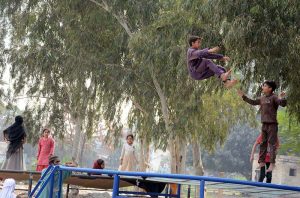 Children enjoying and jumping on trampoline along the roadside setup.