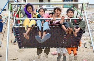 Children enjoy swings at Sadeqi Colony.