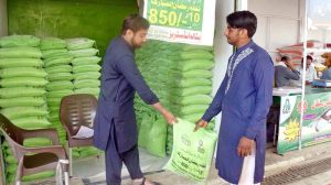 A man purchases flour at the Nighban Ramadan Bazaar at the government-subsidized rate.