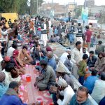 Volunteers distribute food items during Free Iftar at the roadside in Latifabad to deserving people, break their fast in the holy fasting month of Ramazan