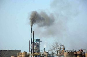 A view of toxic smoke coming out of a factory chimney, polluting the environment and raising concerns for the administration.