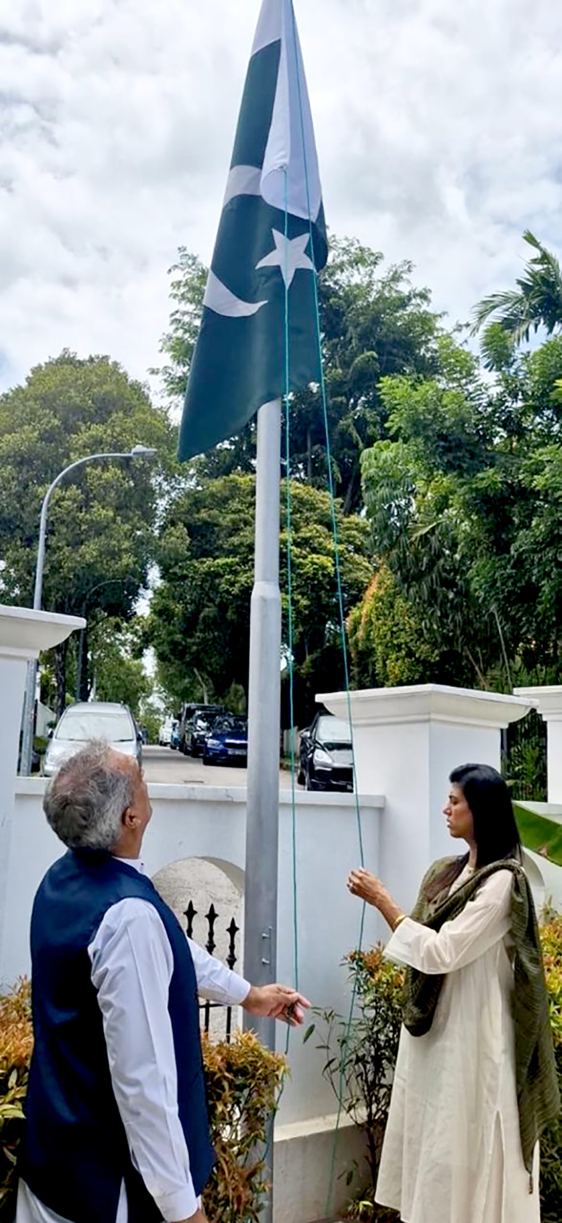 High Commissioner Rabia Shafiq hoisting the national flag at Pakistan House, to the tune of the National Anthem, marking the commemoration of the 86th National Day of Pakistan
