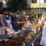 People buying tradional food stuff (Samosa,pakora) from a stall for Iftar during the holy month of Ramazan