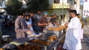People buying tradional food stuff (Samosa,pakora) from a stall for Iftar during the holy month of Ramazan