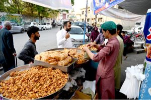 Customers purchase food items from a roadside stall to break their fast during Iftar in the holy month of Ramazan at G-9 market