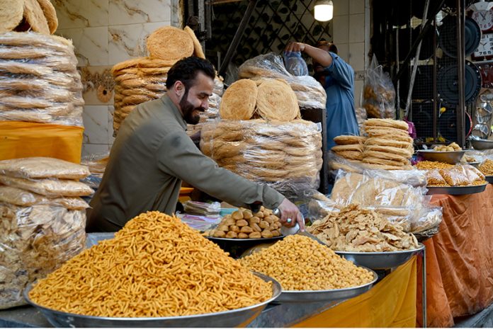 A vendor displays and sells freshly fried Nimko and Papri, attracting customers during the holy month of Ramazan