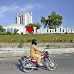 A motorcyclist crosses in front of the newly installed “I Love Islamabad” sculpture at the Convention Center, enhancing the beauty of the federal capital