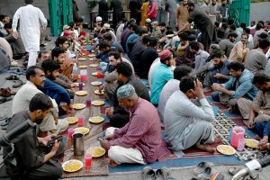 A large number of people break their fast during Free Iftar at the roadside in the city