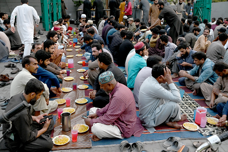 A large number of people break their fast during Free Iftar at the roadside in the city