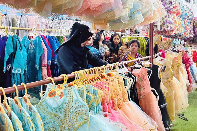 Women along with children are busy selecting dresses at Eid Free Bazaar “Maa Hum Bhi Eid Manyen Gay” organized by JDC Welfare Foundation
