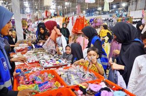 Women along with children are busy selecting dresses at Eid Free Bazaar “Maa Hum Bhi Eid Manyen Gay” organized by JDC Welfare Foundation