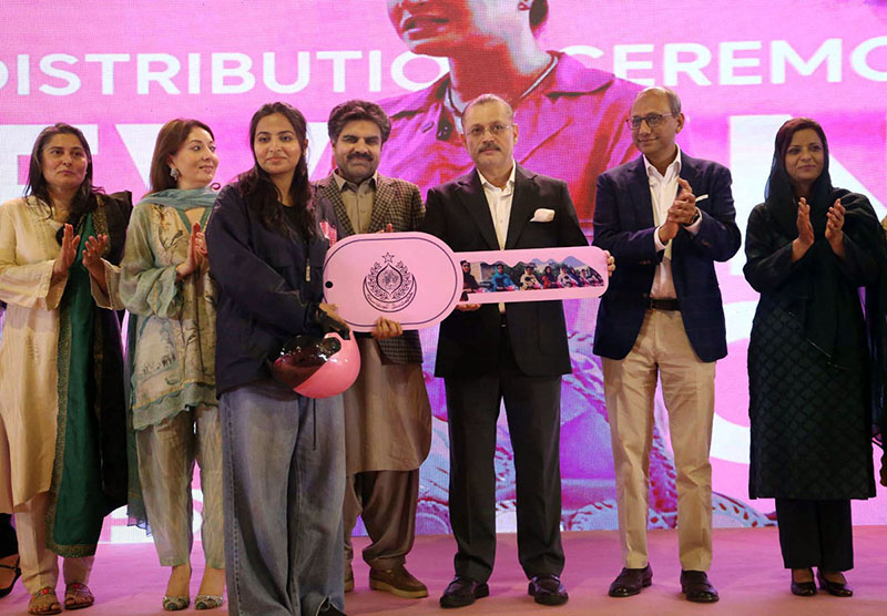 Sharjeel Inam Memon, Sindh Senior Minister and Provincial Minister for Information, Transport and Communication, along with others, hands over the key of a scooty to a woman during a ceremony for the distribution of scooties on the occasion of International Women’s Day at a local hotel