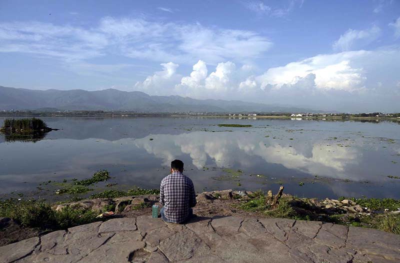 A mesmerizing view of Rawal Lake reflecting clouds on its calm waters