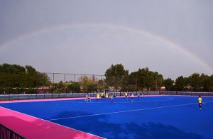 A view of the hockey match played between Crescent Young Hockey Club and ABG Junior Hockey Club during the Hockey Festival organized by Crescent Hockey Club and Fatima Women Hockey Academy at Austro Turf Hockey Stadium, as a rainbow appears in the sky after rainfall in the city.