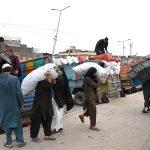 Labourers busy in arranging vegetable bags after unloading from delivery truck at Vegetable Market