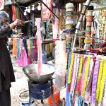 A worker dying clothes at his workplace for customers as people starts preparation for the upcoming Eidul Fitr celebrations at G-9 market in the Federal Capital