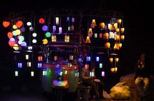 A vendor displaying the decorated colorfull lights to the customers on his rikhshaw at roadside in the Provincial Capital.