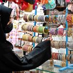A woman is busy purchasing bangles during Eid shopping at Resham Gali in connection with upcoming Eidul Fitr preparations