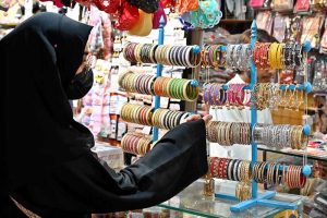 A woman is busy purchasing bangles during Eid shopping at Resham Gali in connection with upcoming Eidul Fitr preparations