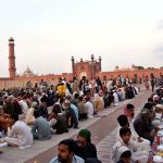 Faithful wait for the Maghrib Azaan to break their fast on the last day of Ramazan at Badshahi Masjid in the provincial capital