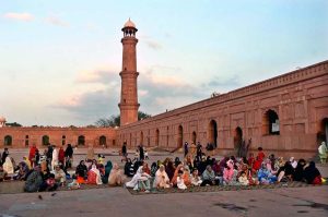 Faithful wait for the Maghrib Azaan to break their fast on the last day of Ramazan at Badshahi Masjid in the provincial capital