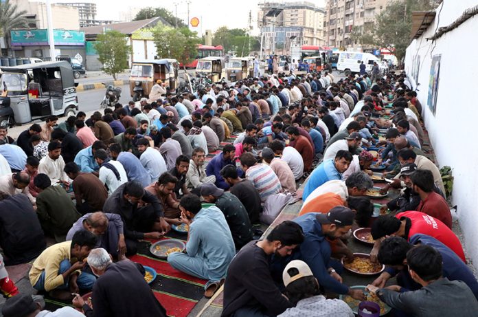 A large number of people break their fast during Free Iftar at the roadside in the city during the holy fasting month of Ramazan