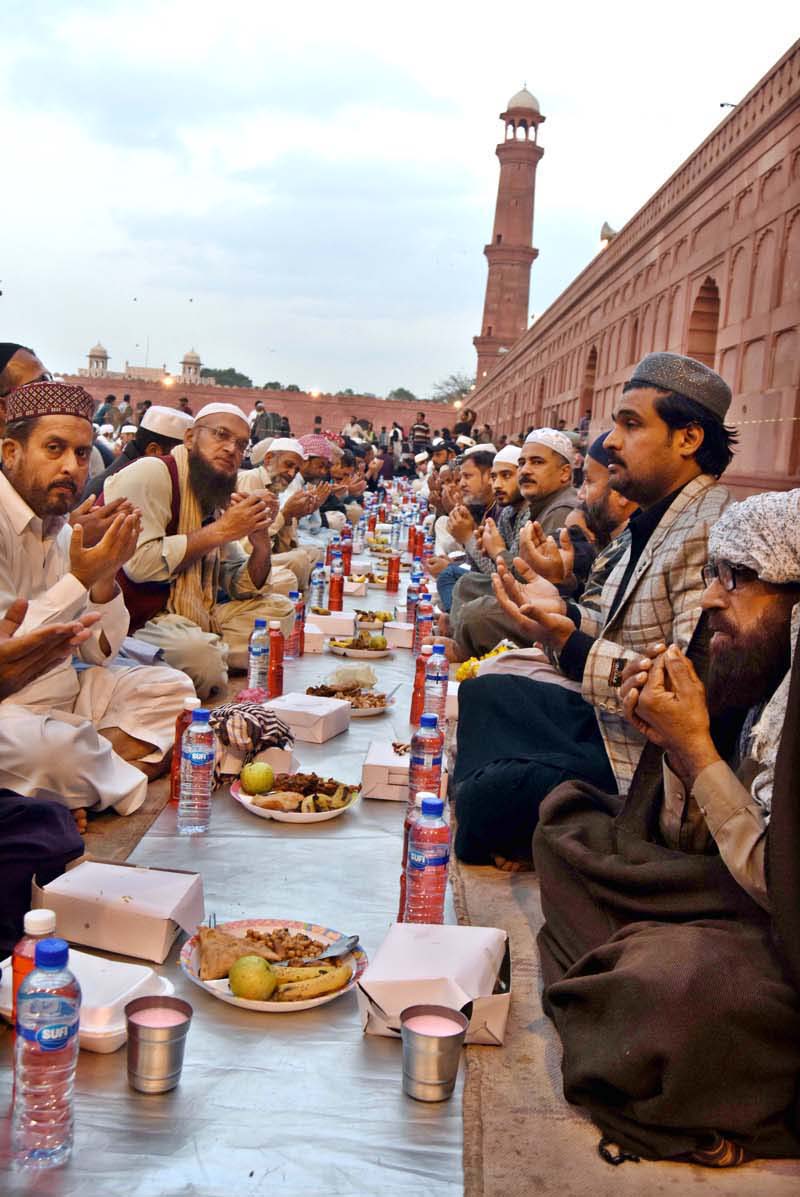 Faithful offering dua while waiting for the Maghrib Azaan to break their fast on the last day of Ramazan at Badshahi Masjid in the provincial capital