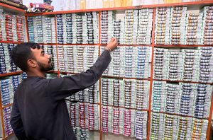 A shopkeeper matching thread color for preparing clothes at Resham Gali in connection with upcoming Eidul Fitr.