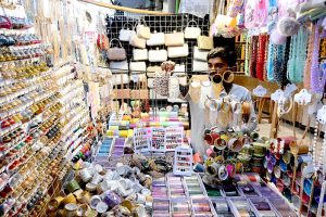 A shopkeeper matching thread color for preparing clothes at Resham Gali in connection with upcoming Eidul Fitr.