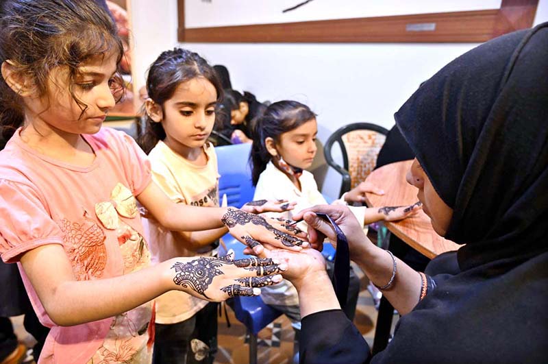 Young girls are decorating their hands with henna (Mehndi) in preparation for Eid-ul-Fitr at the Press Club
