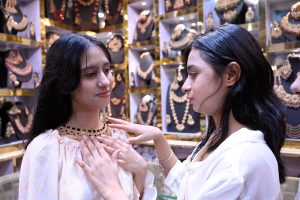 Girls busy in shopping while trying a necklace during preparations for Eid-ul-Fitr.