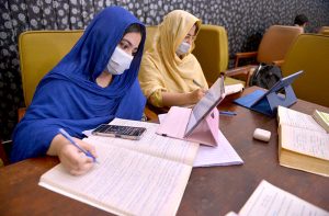 Students take notes from e-books on tablets in the lounge of Shuhada-e-APS Public Library ahead of World Book Day.