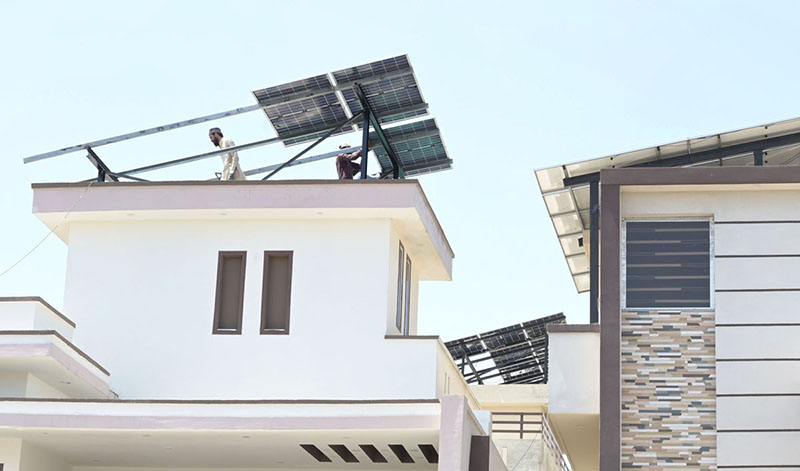 Technicians mount solar panels on a residential rooftop as urban families increasingly turn to renewable energy to hedge against skyrocketing electricity tariffs