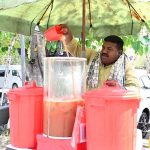A vendor selling traditional summer drink at his roadside setup in the Provincial Capital