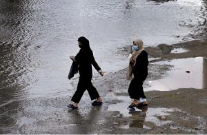 A view of a vehicle making its way through accumulated rainwater as showers hit the city