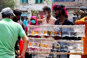 A customer selects small fish as pets from a vendor at the Friday Bazaar in Latifabad Unit 12