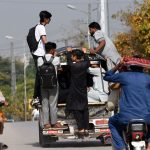 People travel dangerously while hanging from a Suzuki van on a busy Lehtrar road, prompting the need for the concerned authorities to take notice of widespread