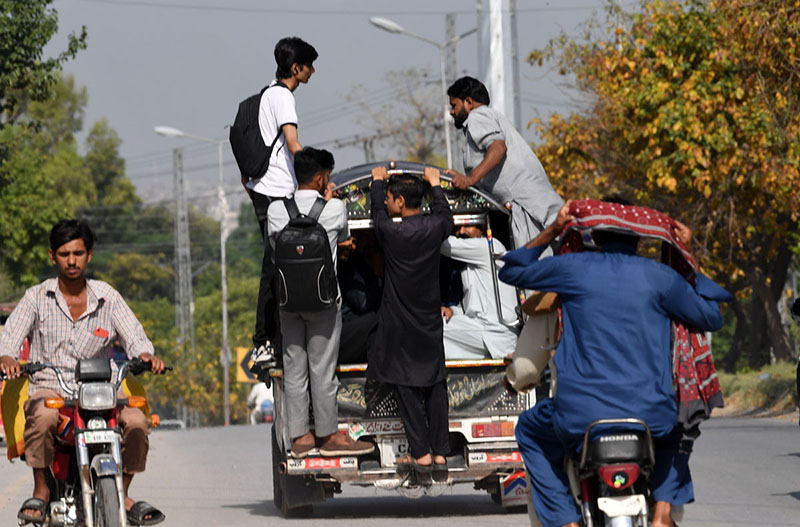 People travel dangerously while hanging from a Suzuki van on a busy Lehtrar road, prompting the need for the concerned authorities to take notice of widespread