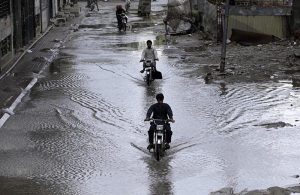 A view of a vehicle making its way through accumulated rainwater as showers hit the city