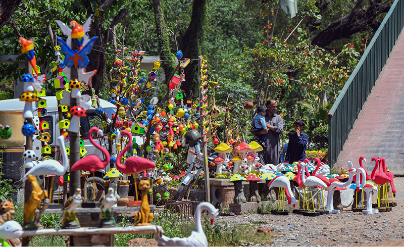 A display of colorful garden ornaments and birdhouses brightens a roadside stall in the federal capital