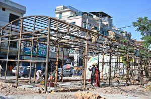 Labourers are busy preparing the structure of a shed for fruit and vegetable stalls in Shamsabad.