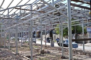 Labourers are busy preparing the structure of a shed for fruit and vegetable stalls in Shamsabad.