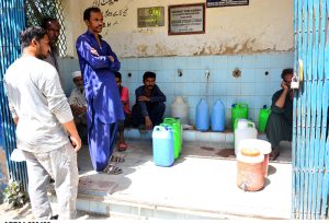 Residents waiting for their turn to fill water pots at a water filtration plant at Pathan Colony.
