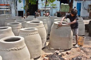 A potter is busy making a traditional tandoor (oven) at his workplace on the outskirts of the city.