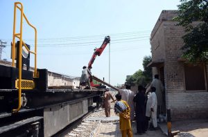 Railway workers carry out track maintenance using heavy machinery to ensure safe and smooth train operations.