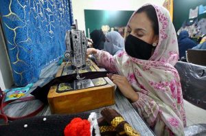 A tailoring instructor guides a trainee during a garment stitching class at Fixit Skill Centre. 