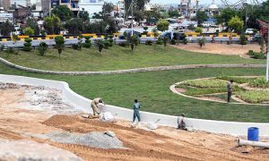 Laborers busy in beautification work at Koral Chowk Interchange on the Expressway in the Federal Capital