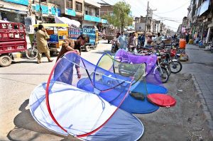 A worker prepares a traditional currency-note garland used in wedding ceremonies at his shop in a local market